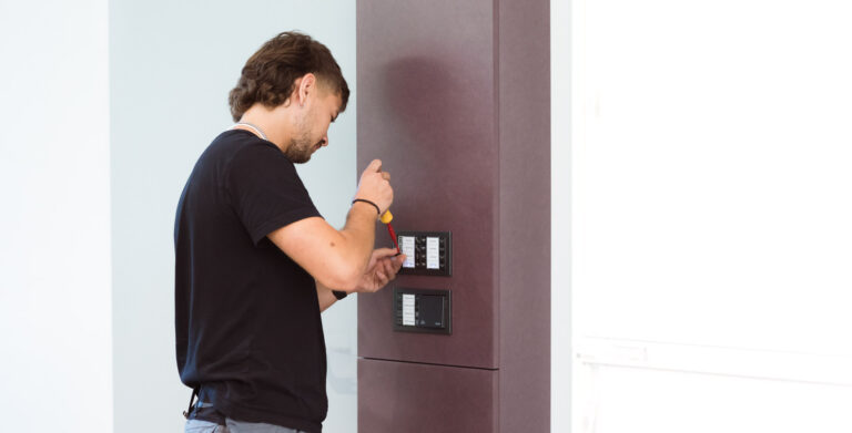 Ein Elektriker arbeitet konzentriert an einem Steuerungspanel, zeigt Professionalität und technisches Know-how. Perfekt für die Darstellung der vielfältigen Dienstleistungen von Perfotech.
